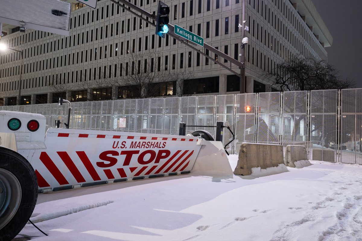 The Federal Courthouse in St. Paul and Ramsey County Downtown Service Center behind security fencing the night before opening statements in trial of officers accused of violating George Floyd's civil rights. Barricades block off a block to be used as a public gathering space