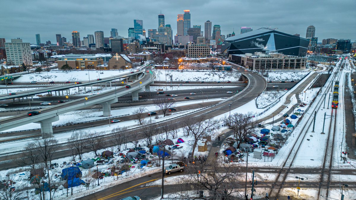 Cedar Riverside encampment residents push to cart near 15th Avenue South and 6th Street South in Minneapolis on Wednesday. The camp will be evicted this morning because it was the scene of a fatal shooting last week.  