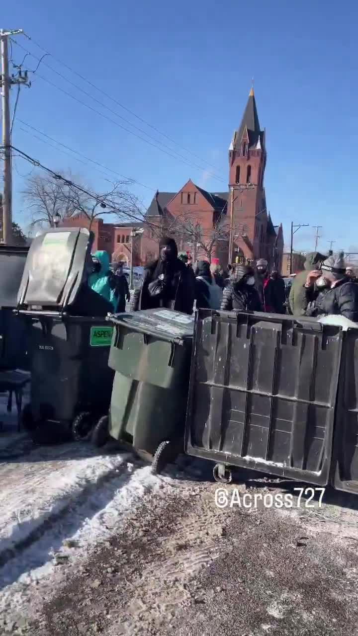 Protesters have barricaded the roadway after an ICE-involved shooting, trapping federal agents at the scene. Crowds are blocking exits as tensions explode and officers reportedly deploy chemical irritants to force a way out