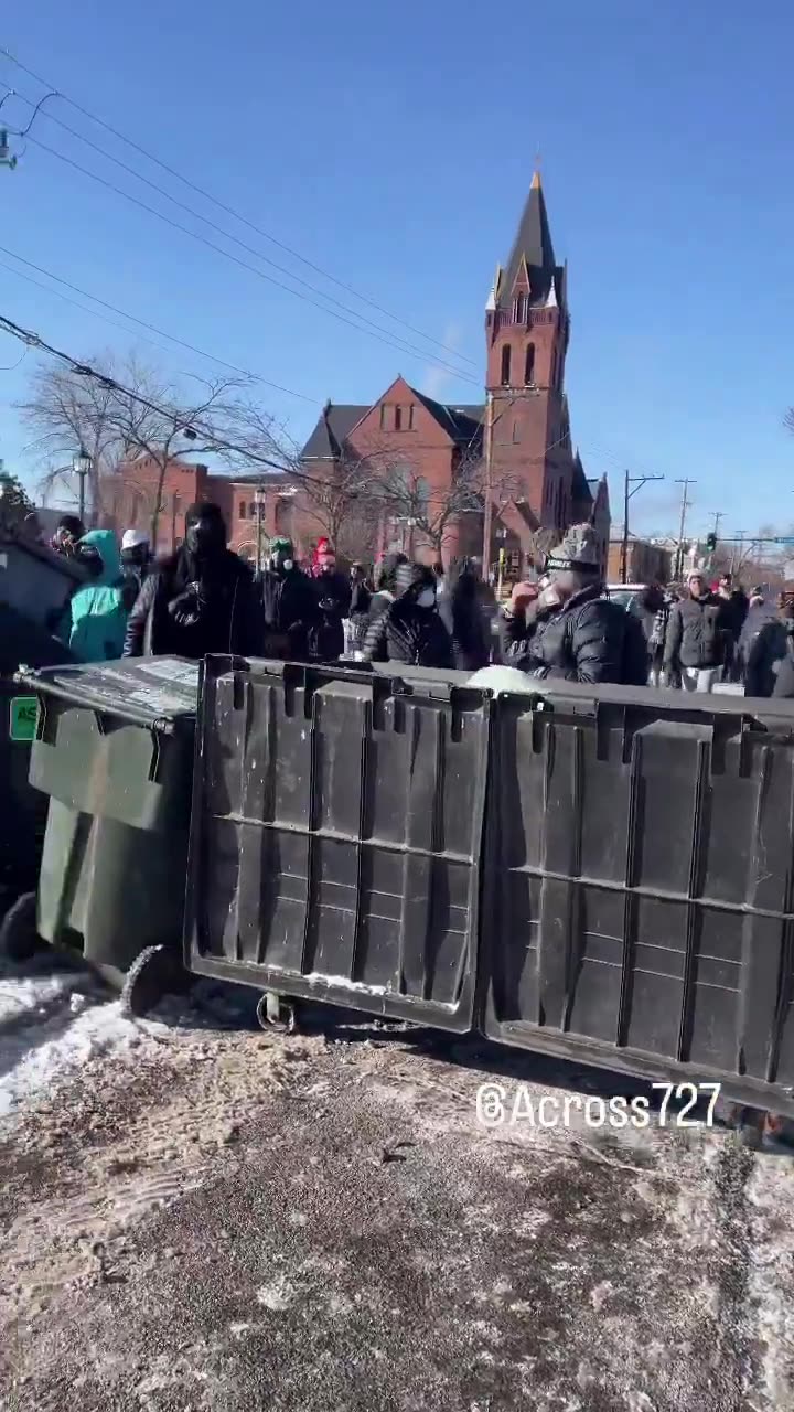 Protesters have barricaded the roadway after an ICE-involved shooting, trapping federal agents at the scene. Crowds are blocking exits as tensions explode and officers reportedly deploy chemical irritants to force a way out